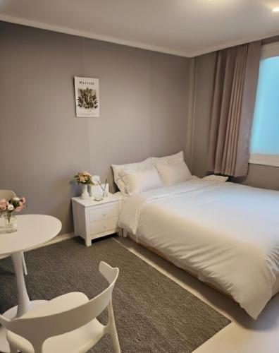a bedroom with a bed and a table and a chair at 스테이미도 Nampo Jagalchi in Busan