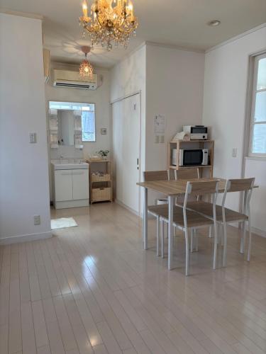 a kitchen and dining room with a table and chairs at ゲストハウスharu in Shingū