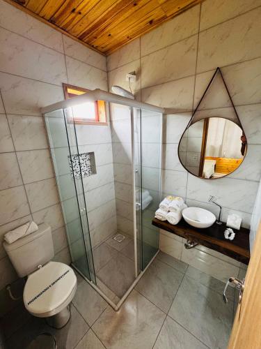 a bathroom with a shower and a toilet and a sink at Cabanas Coimbra in Urubici