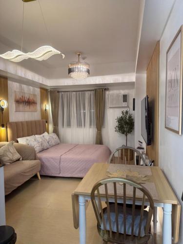 a living room with a bed and a table and a couch at CDO Nest in Cagayan de Oro
