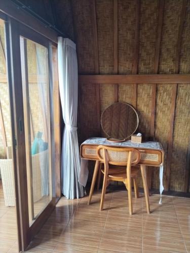 シンガラジャにあるHome Nuh Umajeroの窓のある部屋にあるテーブルと椅子