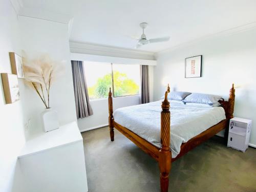 a bedroom with a bed and a window at 2Br Apartment, Pool, 12 mins to Airport in Bilambil Heights