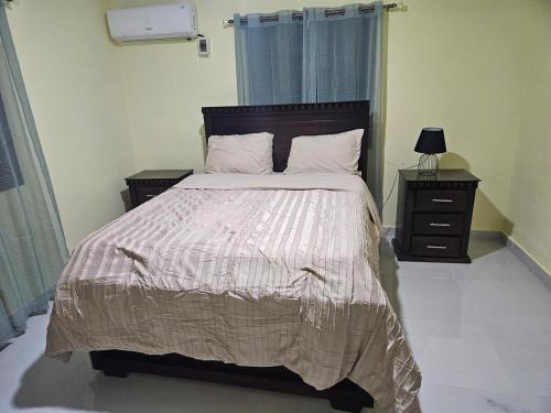 a bedroom with a large bed with two night stands and a lamp at Eastern Breeze in Hainamosa