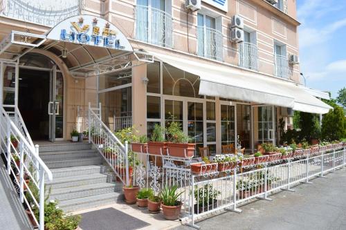 a hotel with potted plants in front of it at ViP HOTEL in Skopje