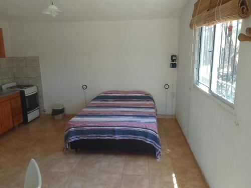 - un lit dans un coin d'une pièce avec fenêtre dans l'établissement Monoambiente El Arcano, à Tanti
