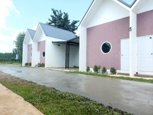 a row of white and pink houses on a street at เดอะแกรนด์เลิฟ รีสอร์ท 