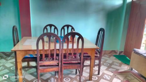 Una mesa de madera con cuatro sillas alrededor. en Chyajalo homestay, en Darjeeling
