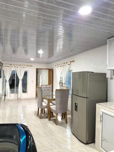 a kitchen and dining room with a table and a refrigerator at Apartamento vacacional por días en Santa Marta in Santa Marta