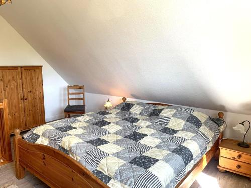 a bedroom with a checkered comforter on a bed at Haus-Am-Sommerdeich-Whg-06 in Sankt Peter-Ording