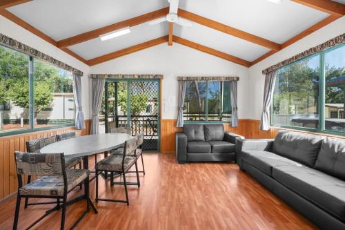 a living room with a couch and a table and chairs at Albury Holiday Park in Albury