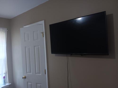 a flat screen tv hanging on a wall at Be Our Guest in Charlotte