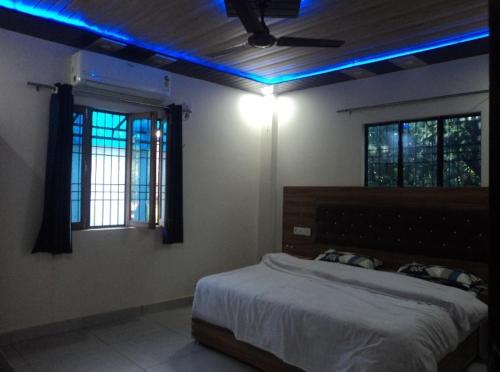 a bedroom with a bed with blue lights on it at Corbett view homestay in Belparāo