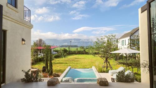 a pool in a yard with a view of a field at La Moon Da Villa Khaoyai in Ban Bung Toei