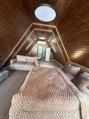 Umm Aljulud Cottages 01 في عجلون: غرفة نوم بسرير كبير في سقف خشبي