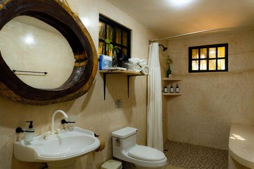 a bathroom with a sink and a toilet and a mirror at Casa Chukum en Rio Lagartos in Río Lagartos