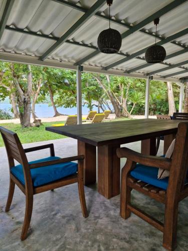 a large wooden table with two chairs and a table at The Mooring Resort in Panwa Beach