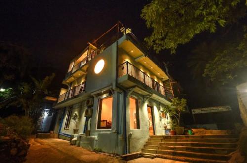 a blue house with stairs in front of it at night at Boho Mount Abu in Mount Ābu