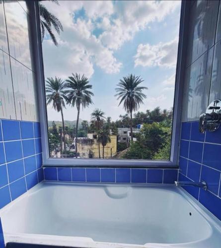 a bath tub in a bathroom with a window at Boho Mount Abu in Mount Ābu