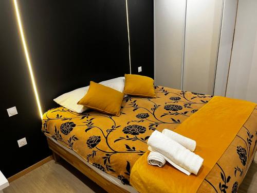 1 dormitorio con 1 cama con sábanas amarillas y almohadas amarillas en La Suite Mulhouse, en Mulhouse