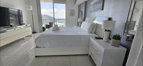 マイアミにあるIcon brickell 48fl river viewのベッドと大きな窓のある白い寝室