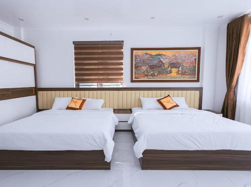 une chambre avec deux lits et une fenêtre dans l'établissement An Khang Hotel, à Quản Bạ