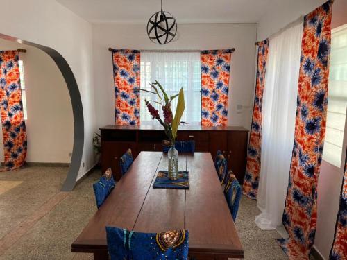 ein Esszimmer mit einem Holztisch und blauen Stühlen in der Unterkunft Villa Rene in Porto-Novo