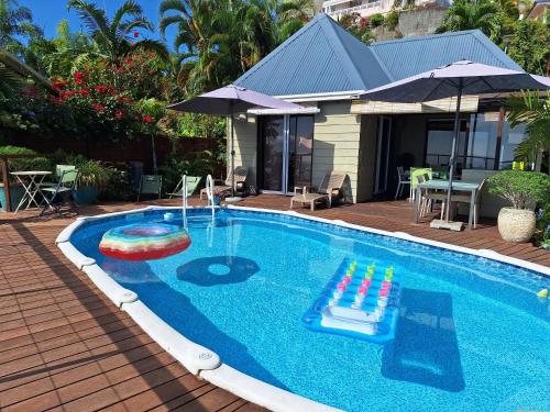 - une piscine avec un jouet et un parasol dans l'établissement Cozy bungalow vue exceptionnelle sur l'océan, à Punaauia