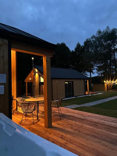 Una terraza de madera con una mesa y sillas. en Lakeview Houses, en Gil Mały