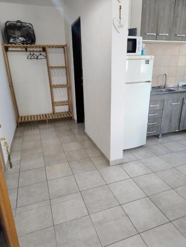 eine Küche mit einem weißen Kühlschrank und Fliesenboden in der Unterkunft Depto Cogli in Ezeiza