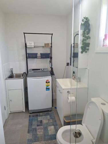 a small bathroom with a toilet and a sink at The Cottage in Moruya