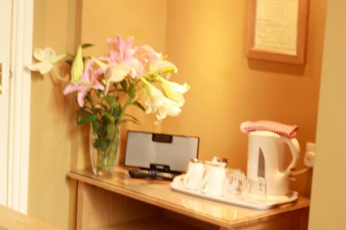 a table with a vase of flowers on it at Brentwood Guest House in York