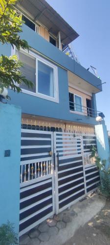 ein blaues Haus mit einem Tor davor in der Unterkunft Koirala Home's in Changunarayan