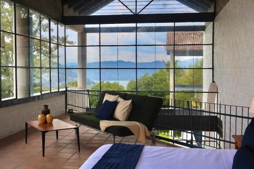 a living room with a couch and a large window at Accommodation with Panoramic View in Valle de Bravo