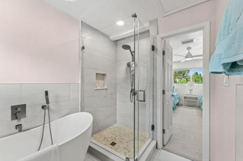 Un baño blanco con bañera y ducha. en 464 Indian Creek Dr, en Cocoa Beach