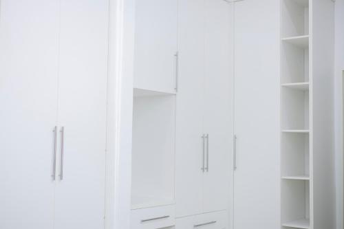 a white closet with white shelves in a room at The Parresia Haven in Harare