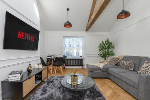 a living room with a couch and a tv at Paradise Boutique Deluxe - Leeds City Center - Steps to Ivy Asia in Leeds