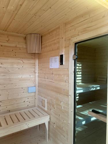 Una sauna de madera con un banco en su interior. en Lakeview Houses, en Gil Mały