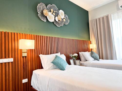 a hotel room with two beds and a clock on the wall at La Nissta Villa 4bdr pool Villa Phuket in Koh Lone