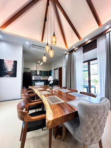 a dining room with a large wooden table and chairs at La Nissta Villa 4bdr pool Villa Phuket in Koh Lone