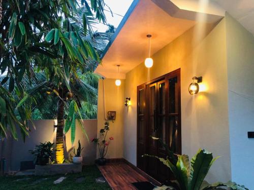 a house with a door and a palm tree at Hiriketiya Green Haven Villa in Dickwella