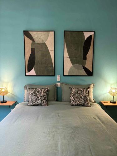 a bedroom with a bed with two pictures on the wall at Villa Petite Anse in Petite Île