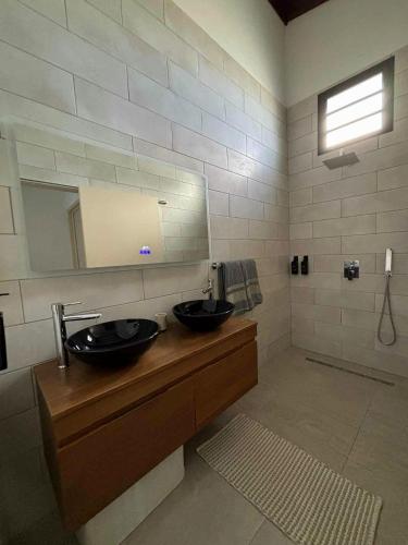 a bathroom with two sinks and a mirror at Villa Petite Anse in Petite Île