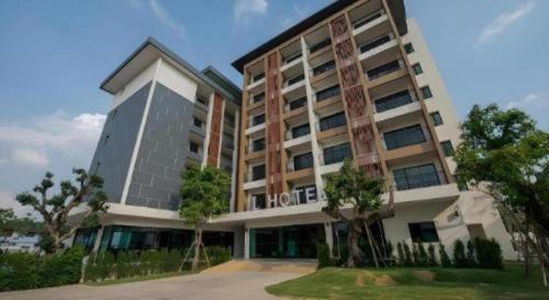 a hotel building with trees in front of it at L Hotel in Khon Kaen