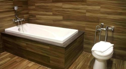 a bathroom with a bath tub and a toilet at Newtown Plaza Hotel in Baguio