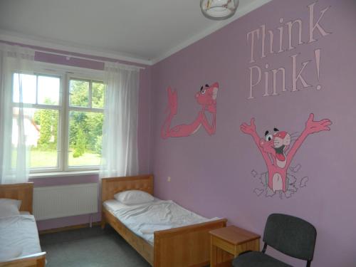 a bedroom with two beds and a pink wall at Rojupe in Roja