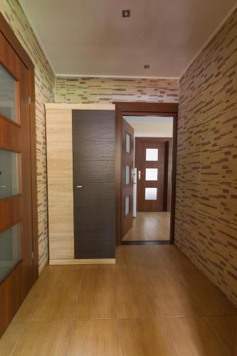 a hallway with a door and a brick wall at Zagroda Nad Kotelnią in Pawłowa