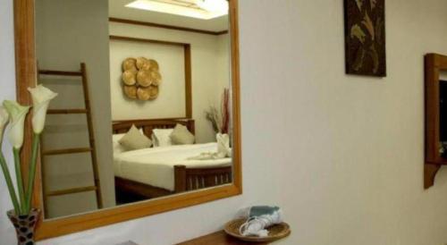 a mirror in a room with a bed and a bed sqor at Small Hotel in Hua Hin