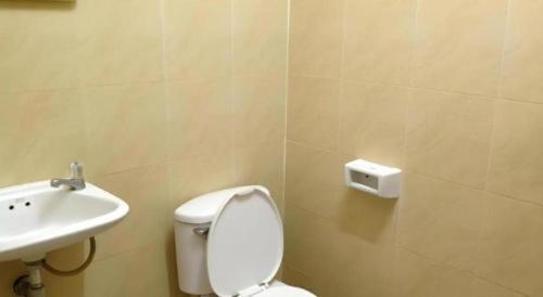 a bathroom with a white toilet and a sink at Numsin Hotel in Ratchaburi