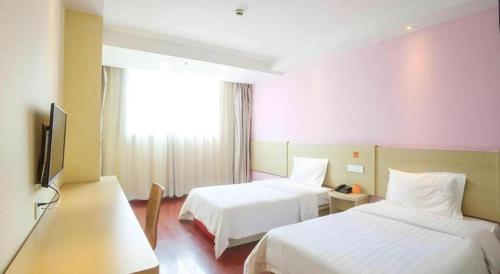 Una habitación de hotel con dos camas y un televisor de pantalla plana. en 7 Days Inn Shaoguan Lechang, en Lechang