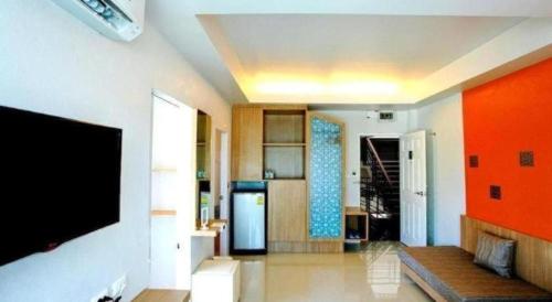 a living room with a flat screen tv on a wall at Tonkok Hotel in Chiang Rai